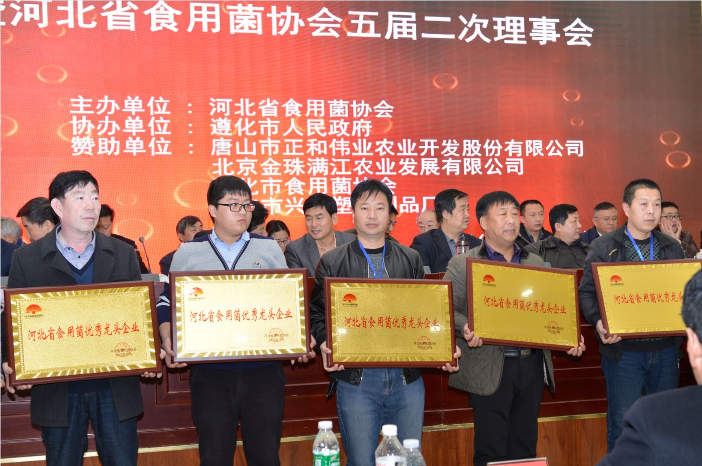 遵化市億昌食用菌科技有限公司被授予&ldquo;河北省食用菌產(chǎn)業(yè)扶貧突出貢獻(xiàn)單位&rdquo;榮譽，張東平（中）接授牌匾（截屏）.JPG